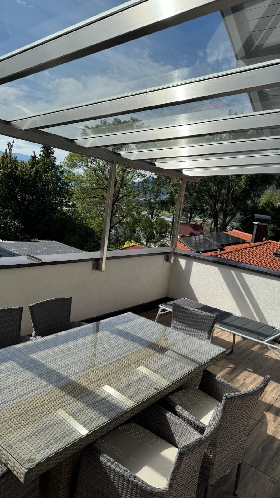 Terrasse mit Glasdach, Sonnenliege und Blick ins Grüne