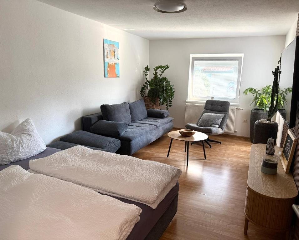 Großzügiges Wohnzimmer mit Sofa, Sessel und Doppelbett